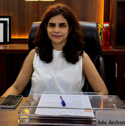 Advocate Archana Chikorde sitting at her office desk in Wakad Pune reviewing legal documents with paper and pen, providing professional legal consultation and advisory services